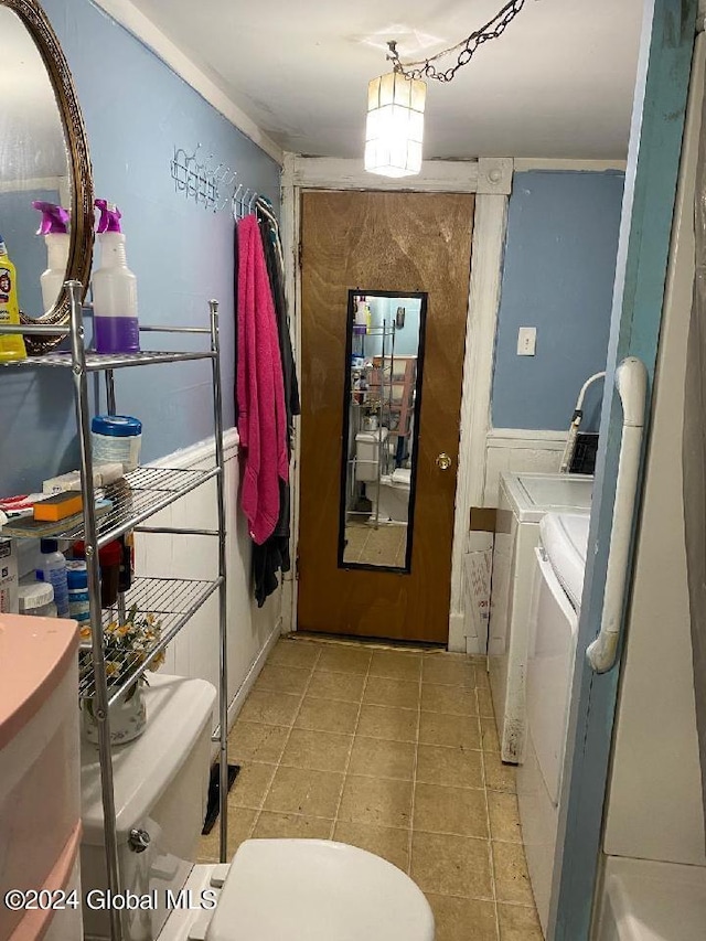 laundry room featuring washer and clothes dryer and light tile patterned floors