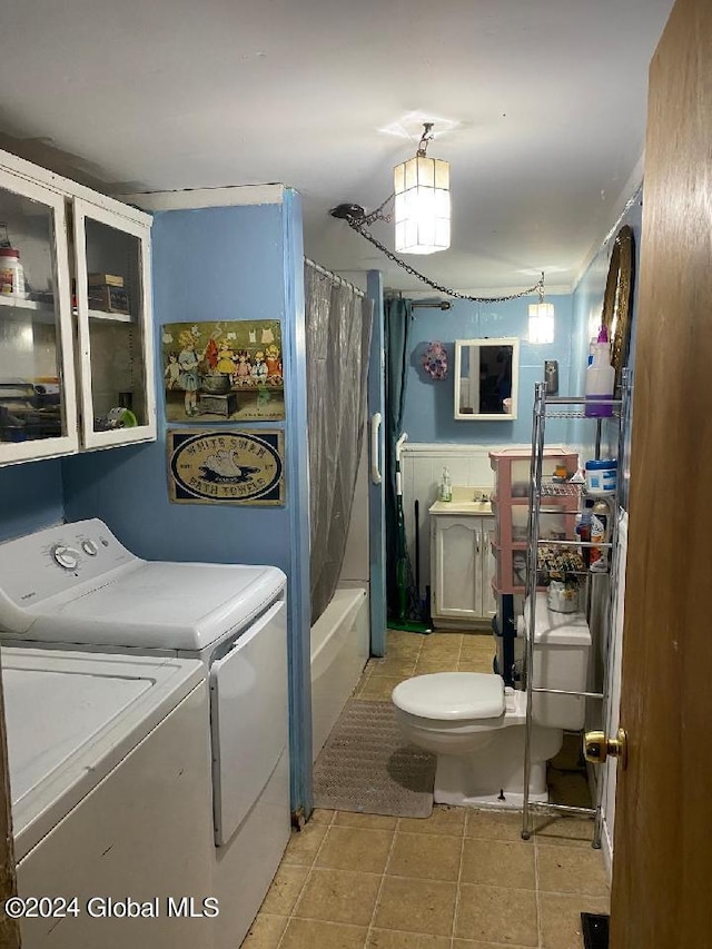 clothes washing area with separate washer and dryer and light tile patterned floors