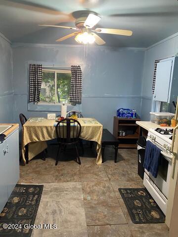 dining area with ceiling fan and ornamental molding