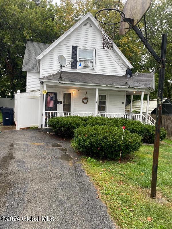 22 Lexington Ave, Gloversville, NY 12078 - view of front facade with covered porch, a shingled roof, and fence