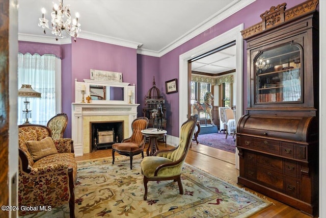 sitting room with an inviting chandelier, hardwood / wood-style flooring, and ornamental molding