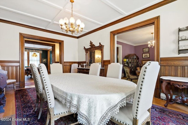 dining area featuring an inviting chandelier, coffered ceiling, crown molding, and hardwood / wood-style floors