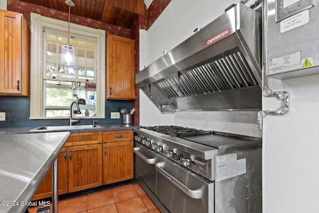 kitchen featuring range with gas cooktop, sink, pendant lighting, light tile patterned floors, and wall chimney exhaust hood