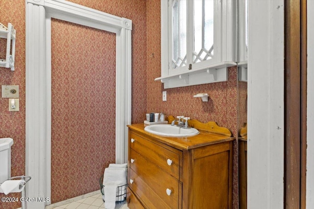 bathroom featuring tile patterned flooring, toilet, and vanity