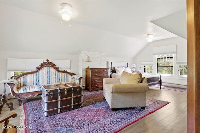 living room featuring brick wall, wood-type flooring, ceiling fan, and vaulted ceiling