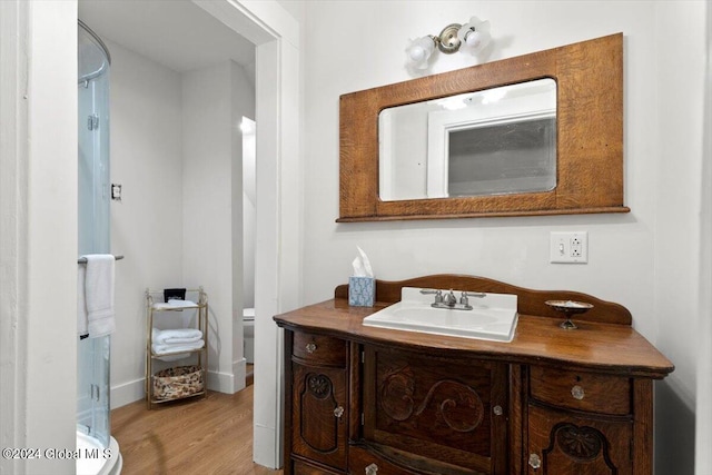 bathroom with vanity, wood-type flooring, and toilet