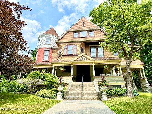 victorian house with a porch and a front yard