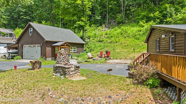 view of front of house featuring an outdoor fire pit, a front lawn, and a garage