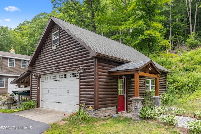 log cabin featuring a garage and an outdoor structure