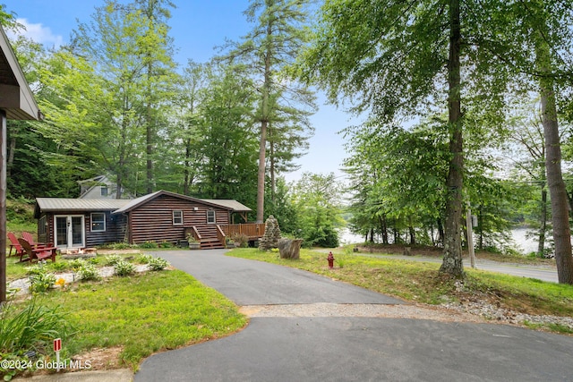 view of front of home featuring a deck with water view and a front lawn