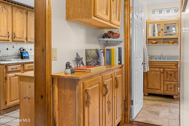 kitchen with sink, backsplash, and light tile patterned floors