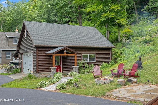 log-style house with a fire pit and a garage