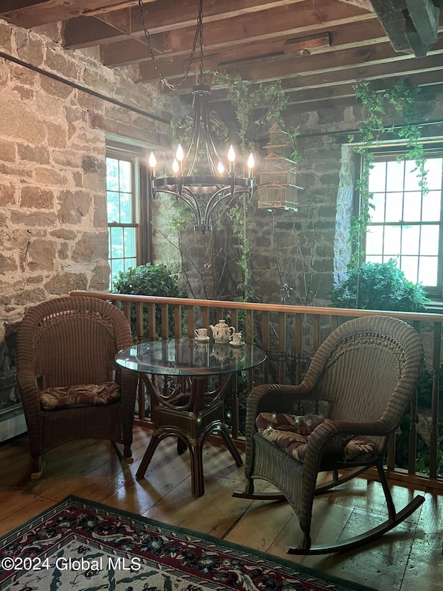 interior space with hardwood / wood-style floors, a notable chandelier, and a baseboard heating unit