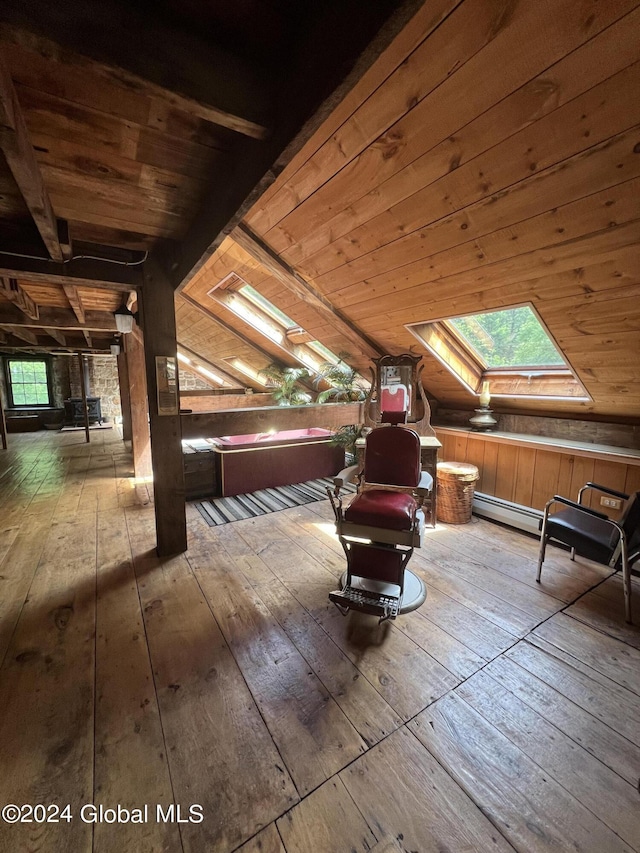 additional living space featuring wood-type flooring, lofted ceiling with skylight, and wood walls