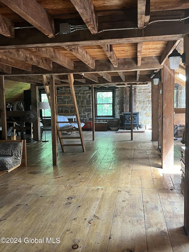 basement featuring hardwood / wood-style flooring and a wood stove