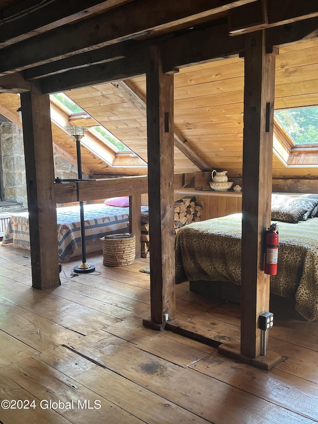 bedroom with hardwood / wood-style floors and a skylight