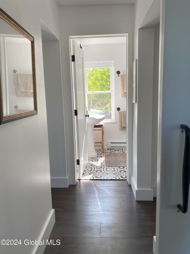 hallway featuring a baseboard radiator, dark wood finished floors, and baseboards