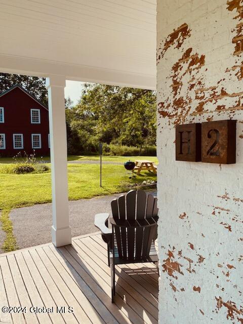 wooden terrace featuring a yard