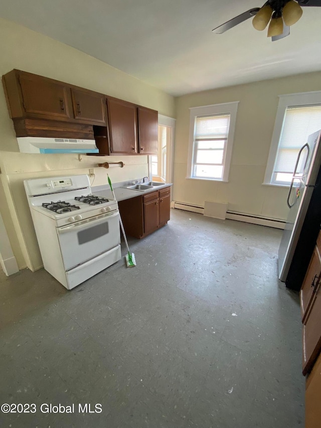 kitchen featuring a baseboard radiator, ceiling fan, wall chimney range hood, white gas range, and light tile patterned floors