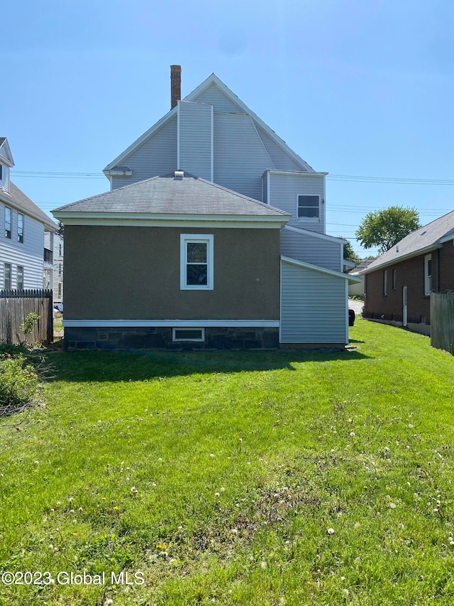 back of house featuring a lawn