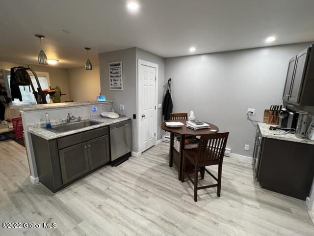 kitchen featuring light wood-type flooring, kitchen peninsula, dishwasher, pendant lighting, and sink