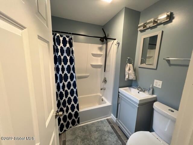 full bathroom with tile patterned floors, shower / bath combo, toilet, and vanity