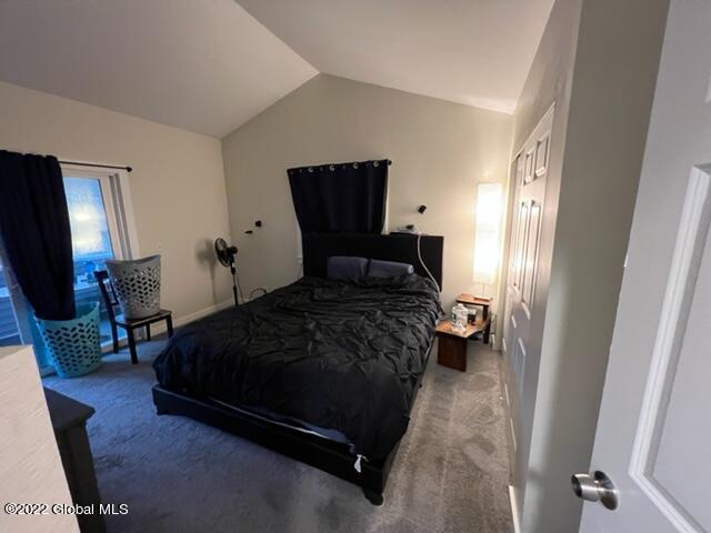 bedroom with vaulted ceiling and carpet