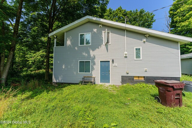 rear view of house featuring a lawn