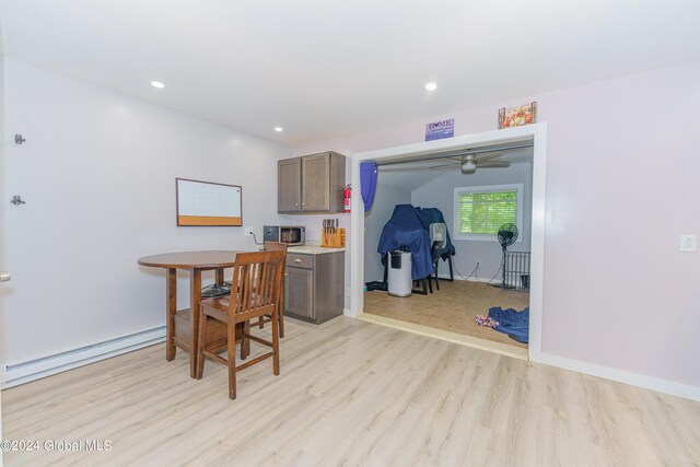 dining space featuring ceiling fan, light hardwood / wood-style flooring, and baseboard heating