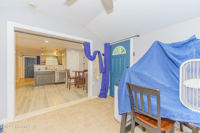 interior space with lofted ceiling, sink, and light tile patterned floors