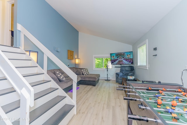 playroom with light hardwood / wood-style flooring and high vaulted ceiling