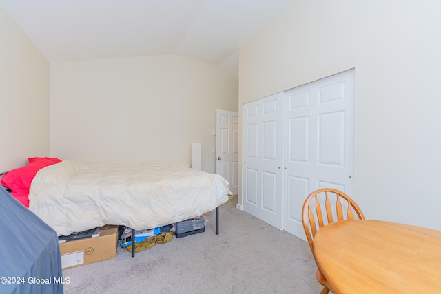 bedroom with carpet floors, a closet, and vaulted ceiling