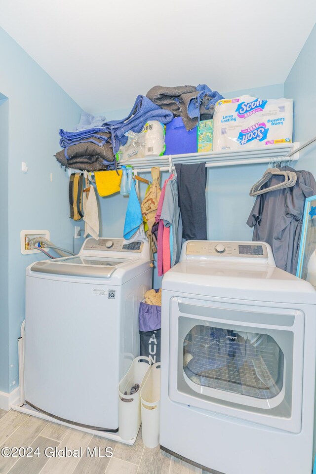 laundry area featuring independent washer and dryer and light hardwood / wood-style flooring