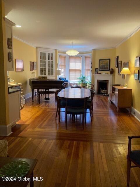 dining area featuring ornamental molding and hardwood / wood-style floors