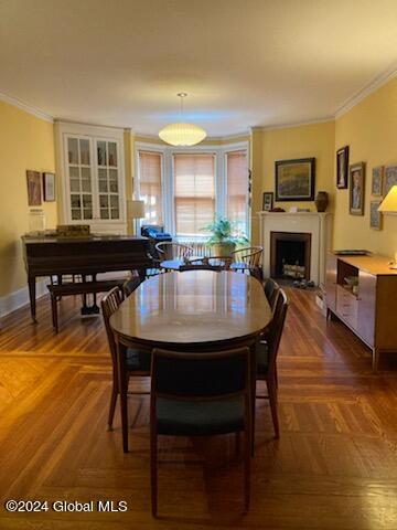 dining room featuring ornamental molding and parquet flooring