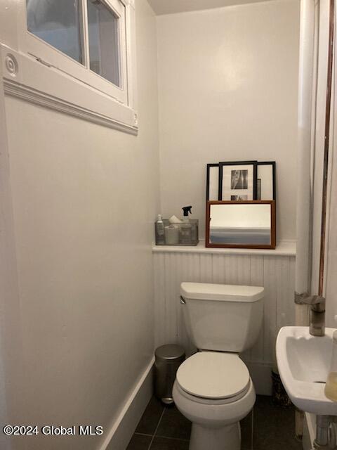 bathroom with sink, toilet, and tile patterned flooring