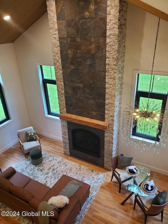 unfurnished living room featuring wood-type flooring, a wealth of natural light, a fireplace, and high vaulted ceiling