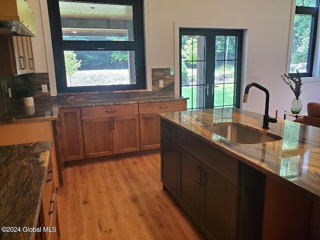 kitchen with tasteful backsplash, stone countertops, sink, and a healthy amount of sunlight