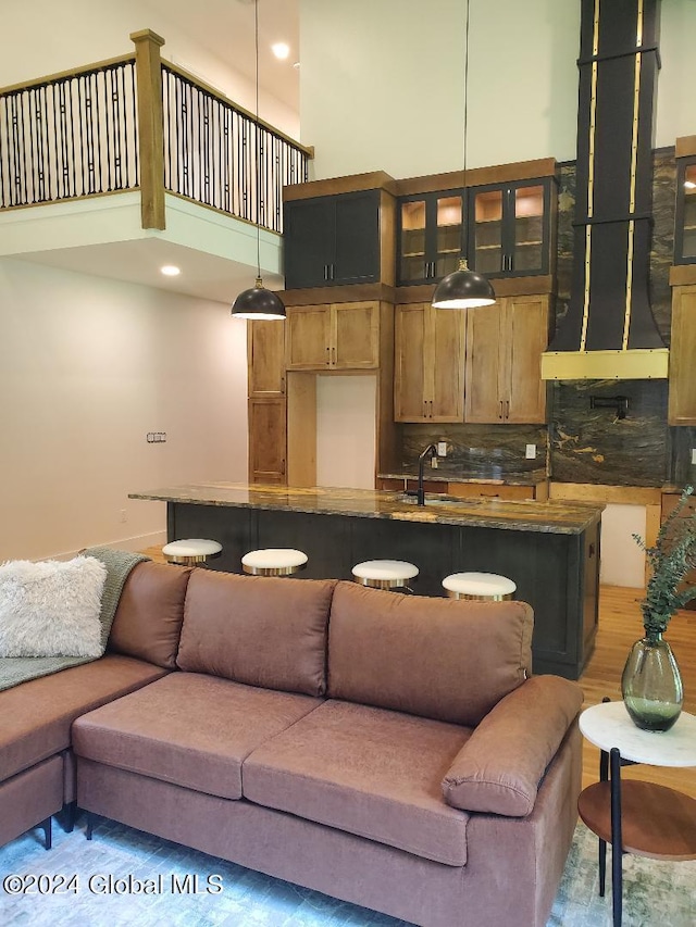 living room with hardwood / wood-style flooring, sink, and a high ceiling