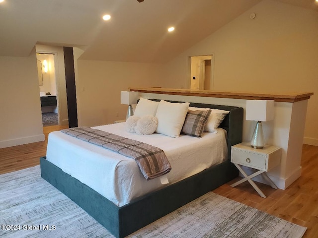 bedroom with lofted ceiling and light wood-type flooring