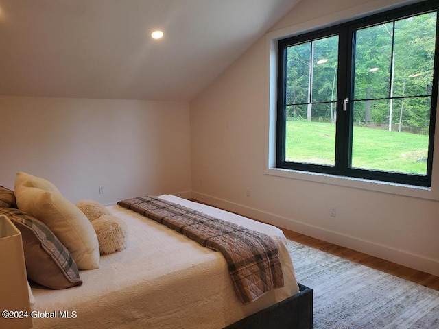 bedroom with lofted ceiling and wood-type flooring