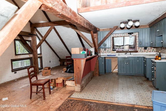 kitchen featuring sink, decorative backsplash, and lofted ceiling with beams