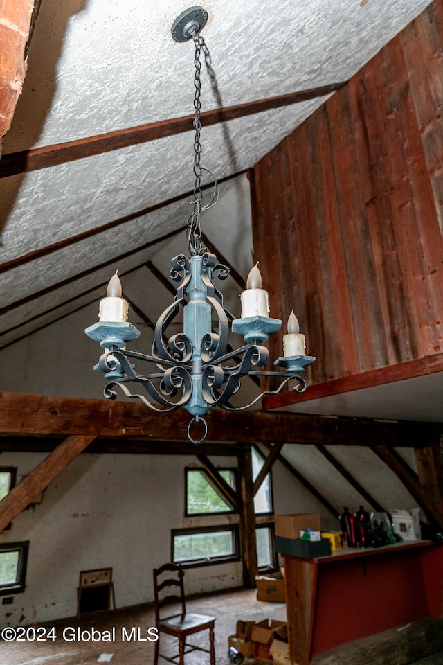 details with wood walls, a chandelier, and a textured ceiling