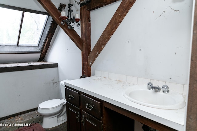 bathroom with a skylight, vanity, and toilet