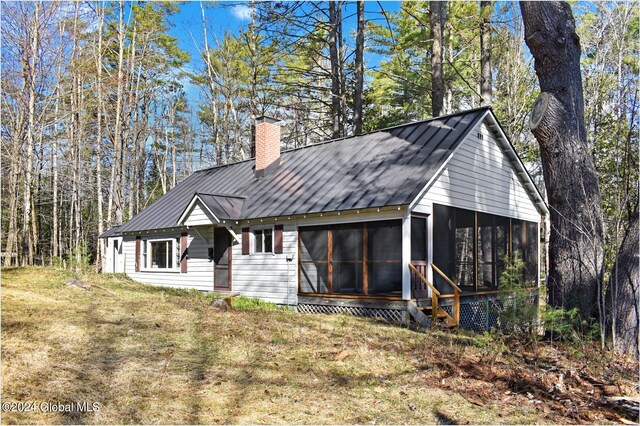67 Adams Ln, Schroon, NY 12870 - rear view of property with a sunroom, a chimney, metal roof, and a yard