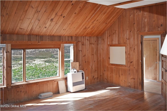 empty room with wooden walls, lofted ceiling, and hardwood / wood-style floors