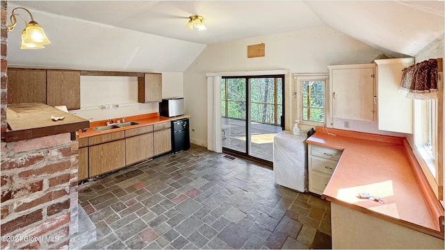 kitchen with lofted ceiling, fridge, and sink