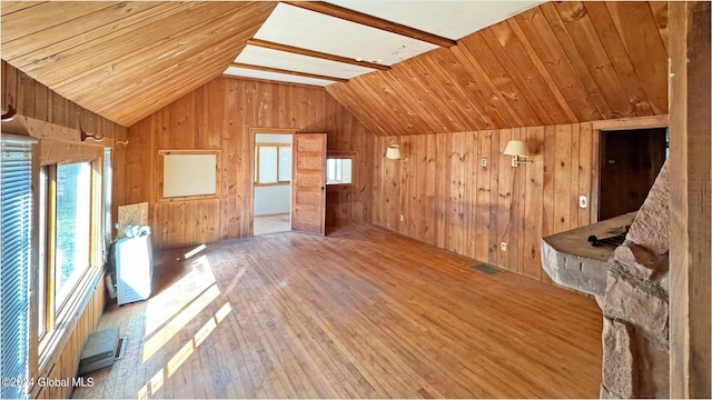 bonus room featuring wood walls and vaulted ceiling with beams