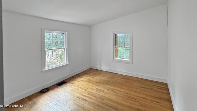 67 Adams Ln, Schroon, NY 12870 - spare room with healthy amount of natural light, vaulted ceiling, wood-type flooring, and baseboards