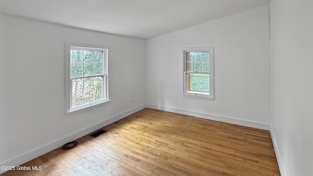 67 Adams Ln, Schroon, NY 12870 - spare room featuring healthy amount of natural light, wood-type flooring, vaulted ceiling, and baseboards